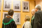 Fotografia de várias pessoas a olhar para quadros na sala de honoris causa, o reitor está presente